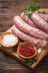 Raw sausages on the wooden board