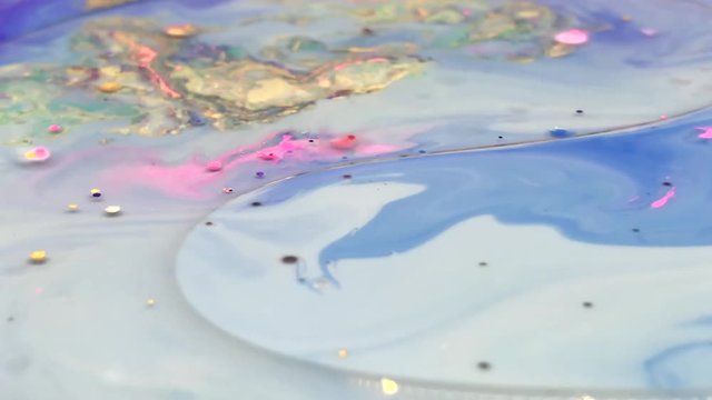 Abstract colorful bubbles marble background with milk oil and soap. Colored inks react to a drop of liquid soap in the oil.