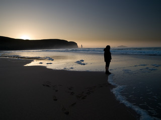 A figure stands at Sandwood Bay at Sunset