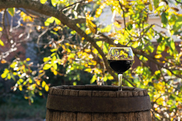 Fototapeta premium Red Wine Bottle and Wine Glass on Wodden Barrel