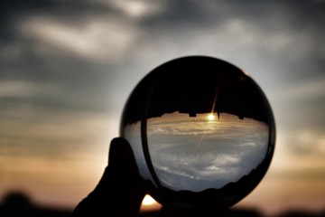 Fototapeta na wymiar Magic upside down perspective of the world using lensball at sunset in urban landscape