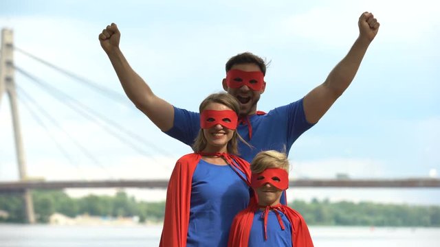 Parents in superhero costumes play with son, psychotherapy to cope with problems