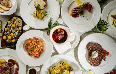 Different types of dishes on the table, top view. Concept for restaurant menu