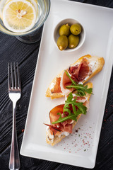 Bruschetta with Parma and goat cheese, olives and almonds. Wine set