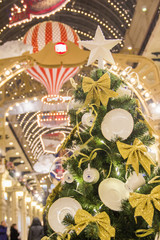 MOSCOW, RUSSIA - DECEMBER 06, 2017:Decorations of GUM mall during winter holidays. White porcelain tea cups and saucers with golden ribbons on green fir