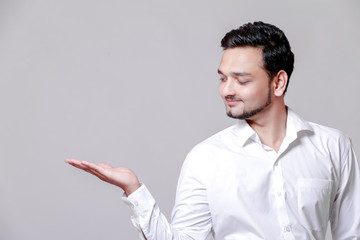 Young Indian man showing on white background