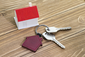 key chain with house symbol and keys on wooden background,Real estate concept