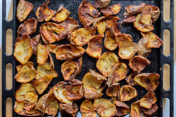 Baked potato skin crisps on a tray.