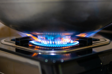 Blue flame from gas stove heating frying pan when cooking food