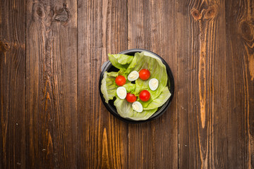 lettuce leaves with cherry tomatoes and quail eggs on a plate