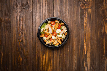 Caesar salad with chicken, cherry tomatoes and quail eggs on a plate
