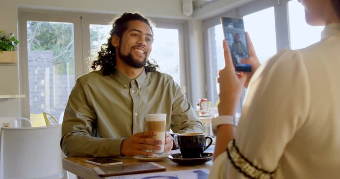 Executive taking picture on smartphone of colleague 4k