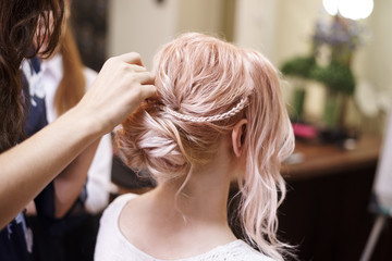 Naklejka premium Hairdressing services.Сreating an evening hairstyle. Hair styling process.