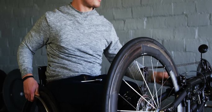 Disabled man repairing wheelchair at workshop 4k