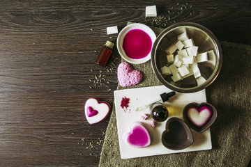 Making soap from pour and melt soap base concept. Soap making ingredients on brown wooden background. melt and pour method, buy a soap base that’s already been made and cured. Copy space. Hobby.