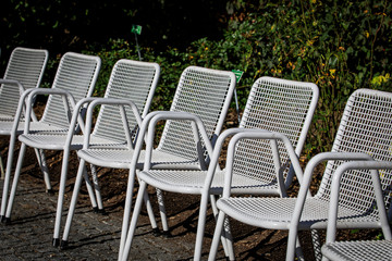 Fototapeta na wymiar Weiße Stuhlreihe im Park