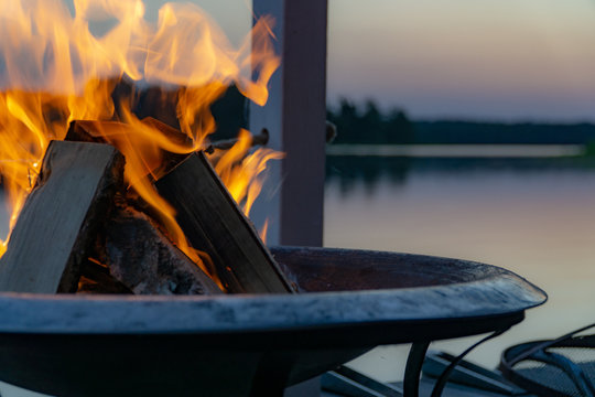 Flammen in einer Feuerschale in der D&auml;mmerung am See