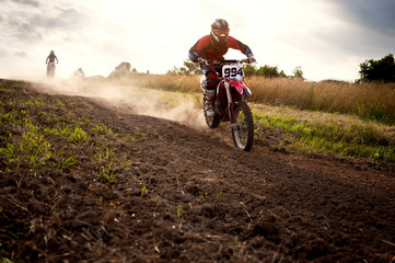 Obraz premium Dirt bikers riding motorcycles on field against sky