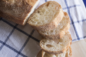 Fresh bread with pieces on a tablecloth.