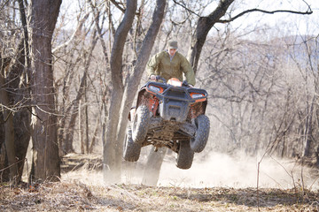 Young man riding quadbike in field © Cavan for Adobe