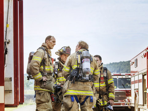Firefighters standing by fire engine