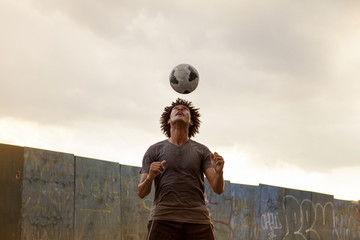Man juggling soccer ball against sky © Cavan for Adobe