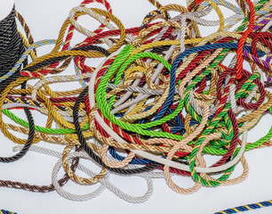 Multi-colored decorative rope scattered in a mess. Textile manufacture, threads, decor.