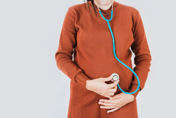 Using stethoscope of Asian women pregnant ,Focus on hand