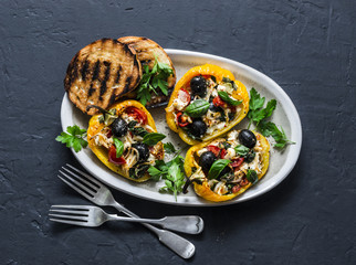 Baked bell peppers stuffed greek salad - delicious appetizers, snacks on a dark background, top view
