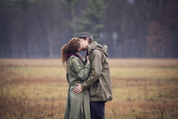 Couple kissing while standing on grassy field © Cavan for Adobe
