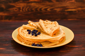 Delicious pancakes with berries on brown wooden background