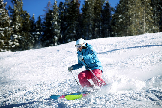 Woman skiing downhill on mountain