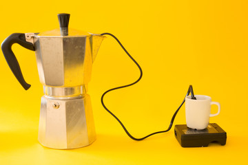 Italian Moka coffee maker like energy recharge, cup of energy on yellow background