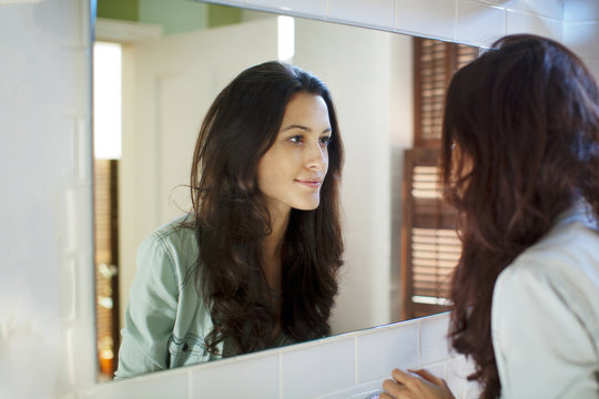 Woman looking into mirror