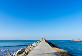 Empty boardwalk along blue beach on bright sunny day