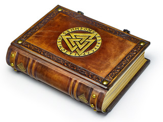 Vintage leather book with gilded Odin's symbol lay down to the table