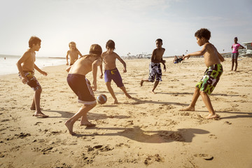 Obraz premium Friends playing soccer at beach