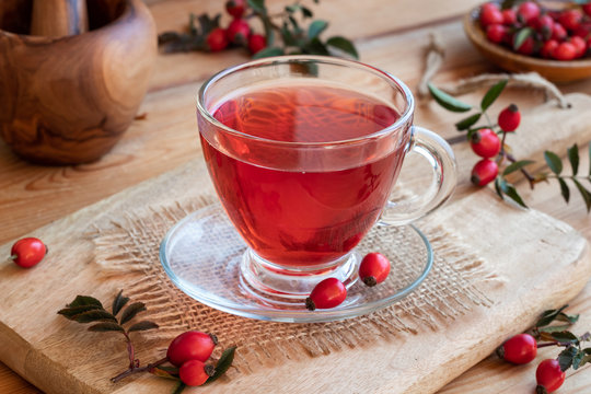 A Cup Of Rose Hip Tea With Fresh Rose Hips