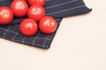 Cherry tomatoes with black kitchen cloth on a background.