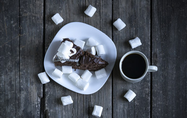 Homemade chocolate cake in white plates on wooden background.