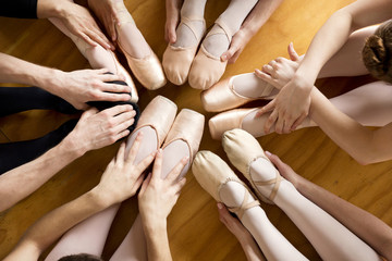 Overhead view of ballerinas holding feet while exercising in ballet studio © Cavan for Adobe