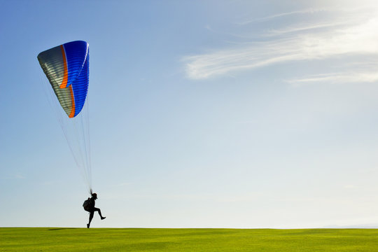 Man taking off with paraglide