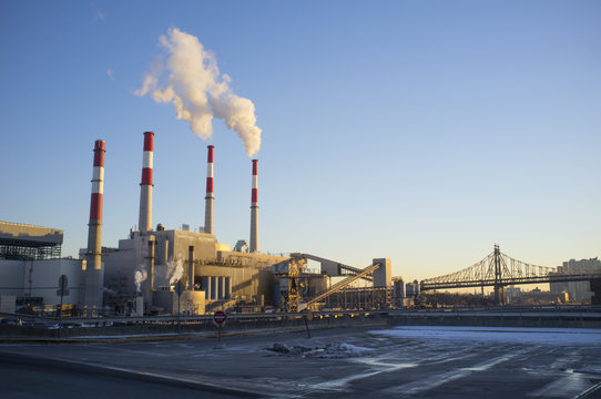Smoke stacks in factory by bridge, New York, USA