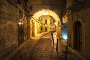 Walkway and buildings in old town illuminated at night, Italy © Cavan for Adobe