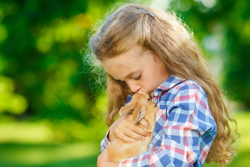 Girl with a cute little rabbit, outdoor, summer day