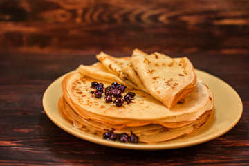 Sweet Breakfast. Pancakes with jam and berries on a wooden table. Close-up food photo.