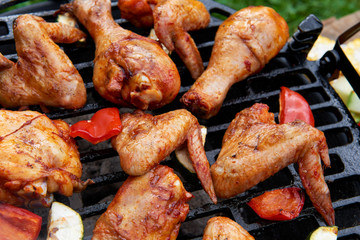 Meat and vegetables during grilling. Assorted types of chicken