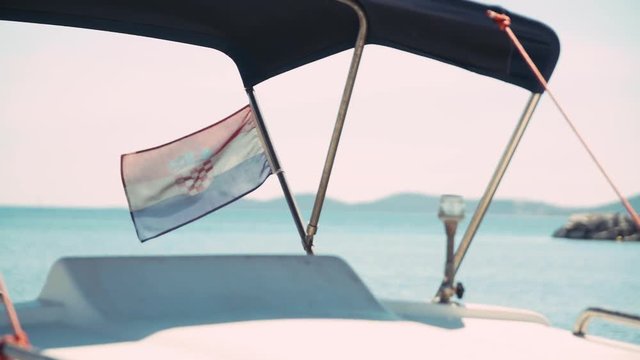 Slow motion clip of a Croatian flag moved by the wind on a boat during some navigation.