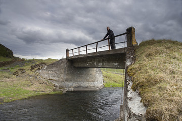 Traveler on a bridge near Gluggafoss waterfall
