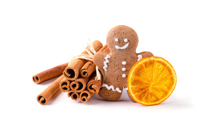 Gingerbread man with cinnamon sticks and dried orange slice isolated on white background